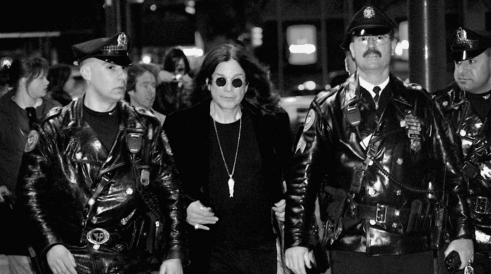 Ozzy Osbourne in 2010. Here photographed with Philadelphia police officers, as he’s leaving a book signing of his autobiography, “I Am Ozzy”. Photo: Kevin Burkett via Wikimedia Commons (CC BY-SA 2.0)